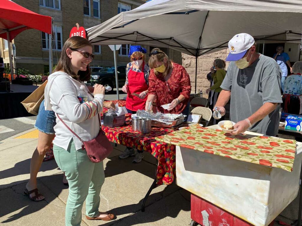 A guest being served delicious apple crisp and vanilla ice cream at the Johnny Appleseed Festival in Leominster, MA