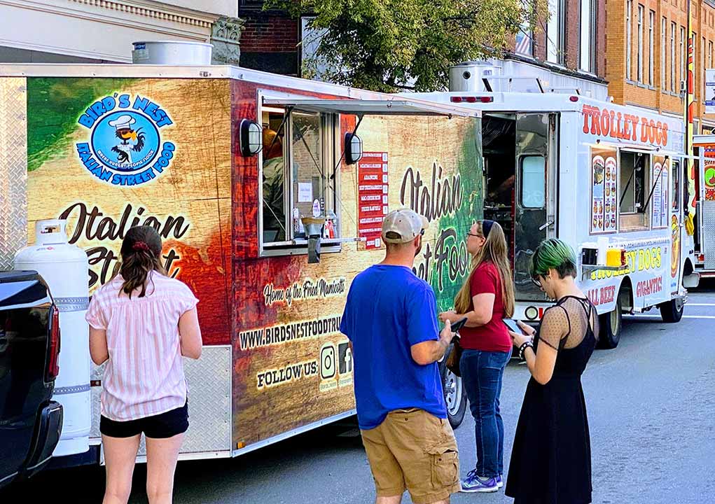 Two food trucks at a food truck festival.